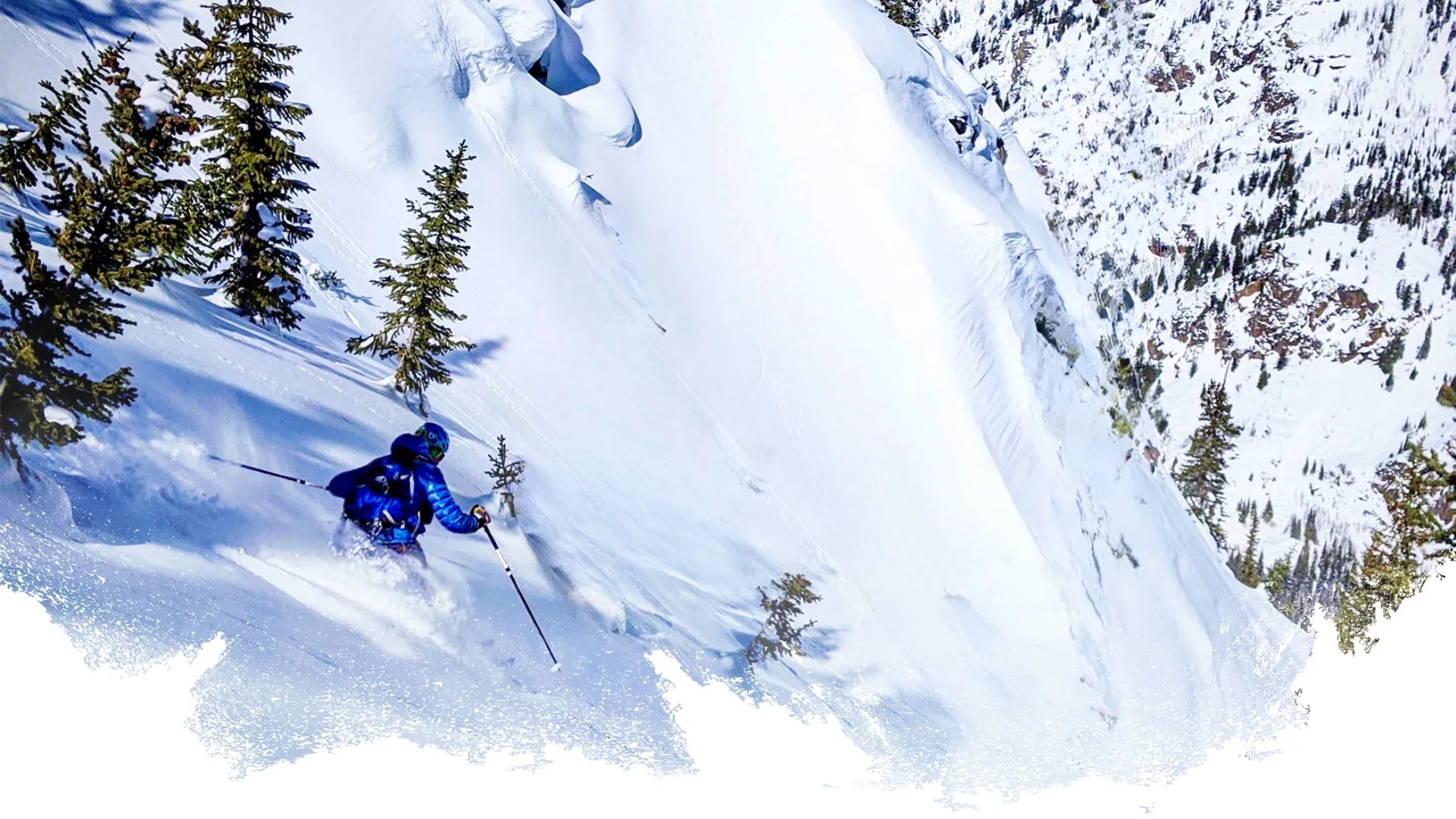 Backcountry skier in blue jacket wearing OutThere backpack